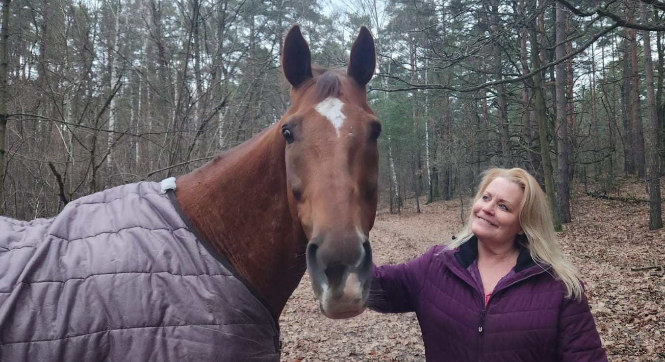 Kim Hoffman with her horse in a peaceful woodland setting
